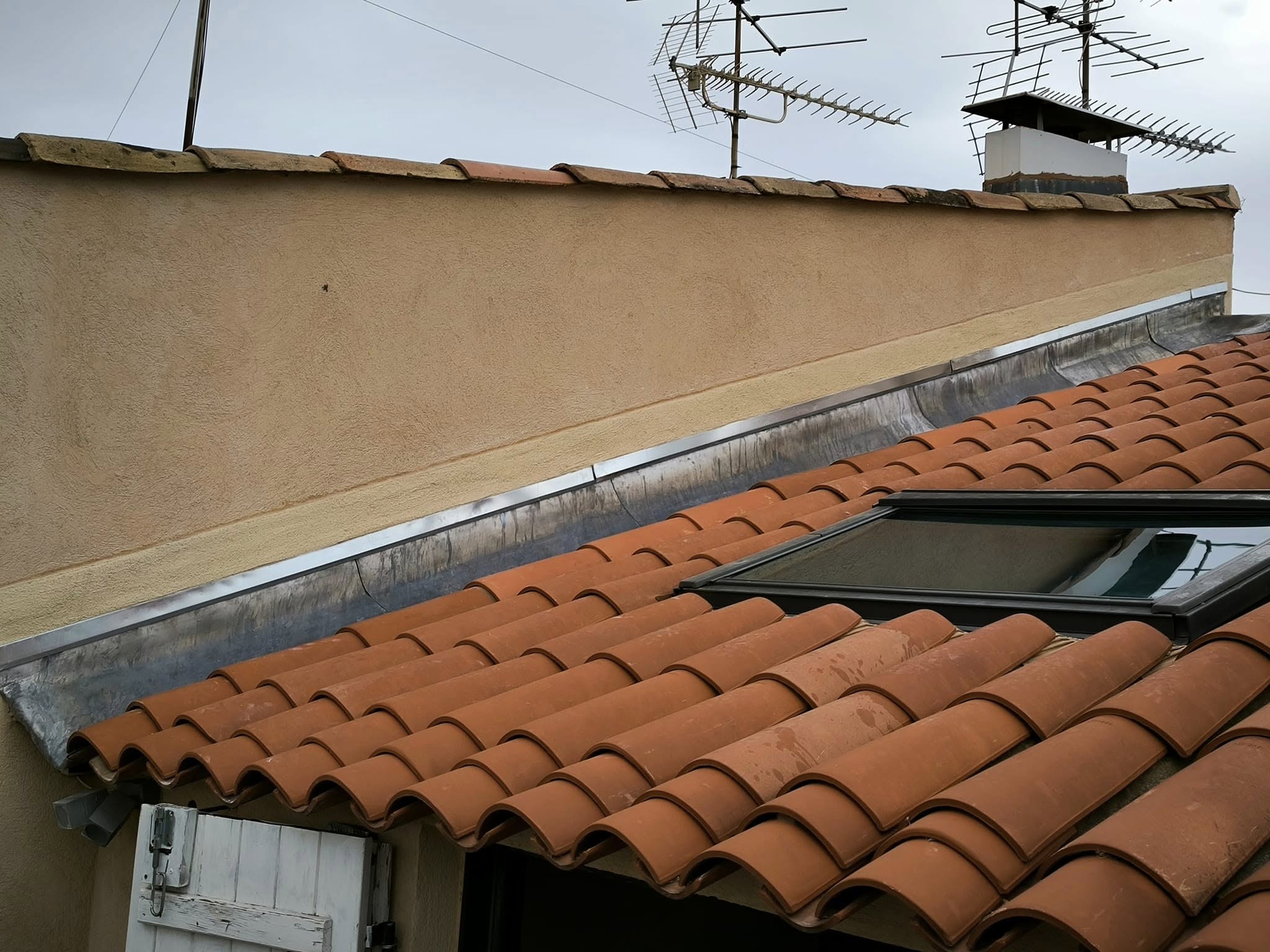 Pose de solin d’étanchéité entre mur et toiture par un couvreur à Aubagne